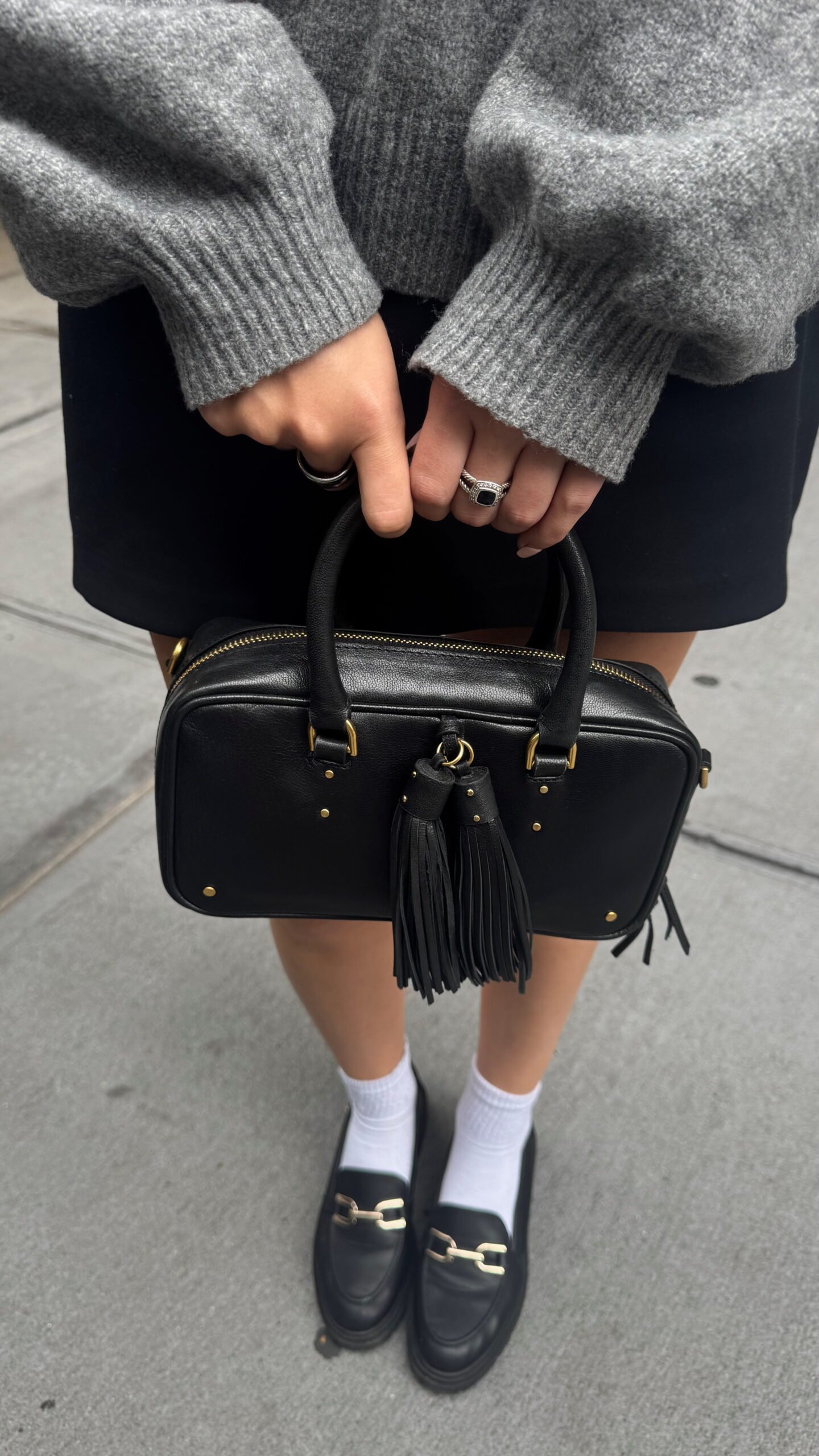 Close-up of black purse paired with casual outfit