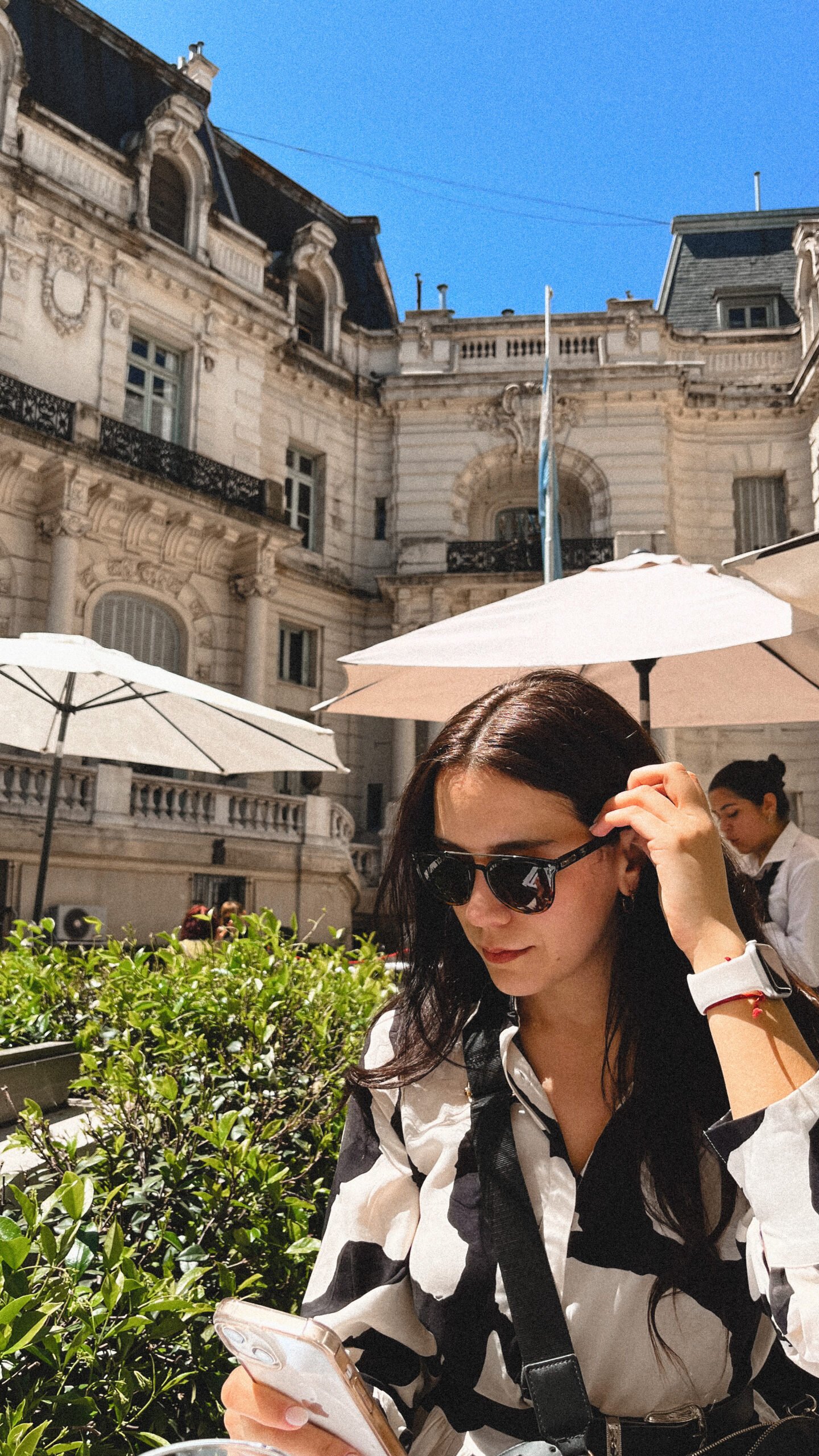 Traveler checking directions on phone at café abroad