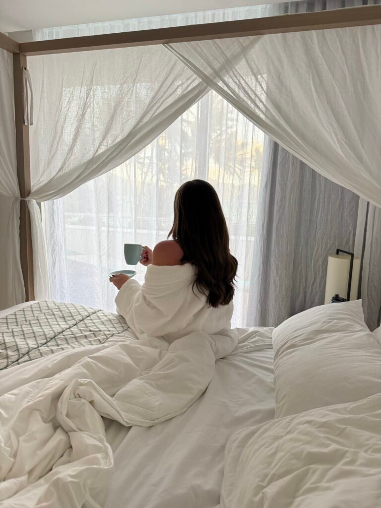 Woman sitting on bed in the morning drinking coffee